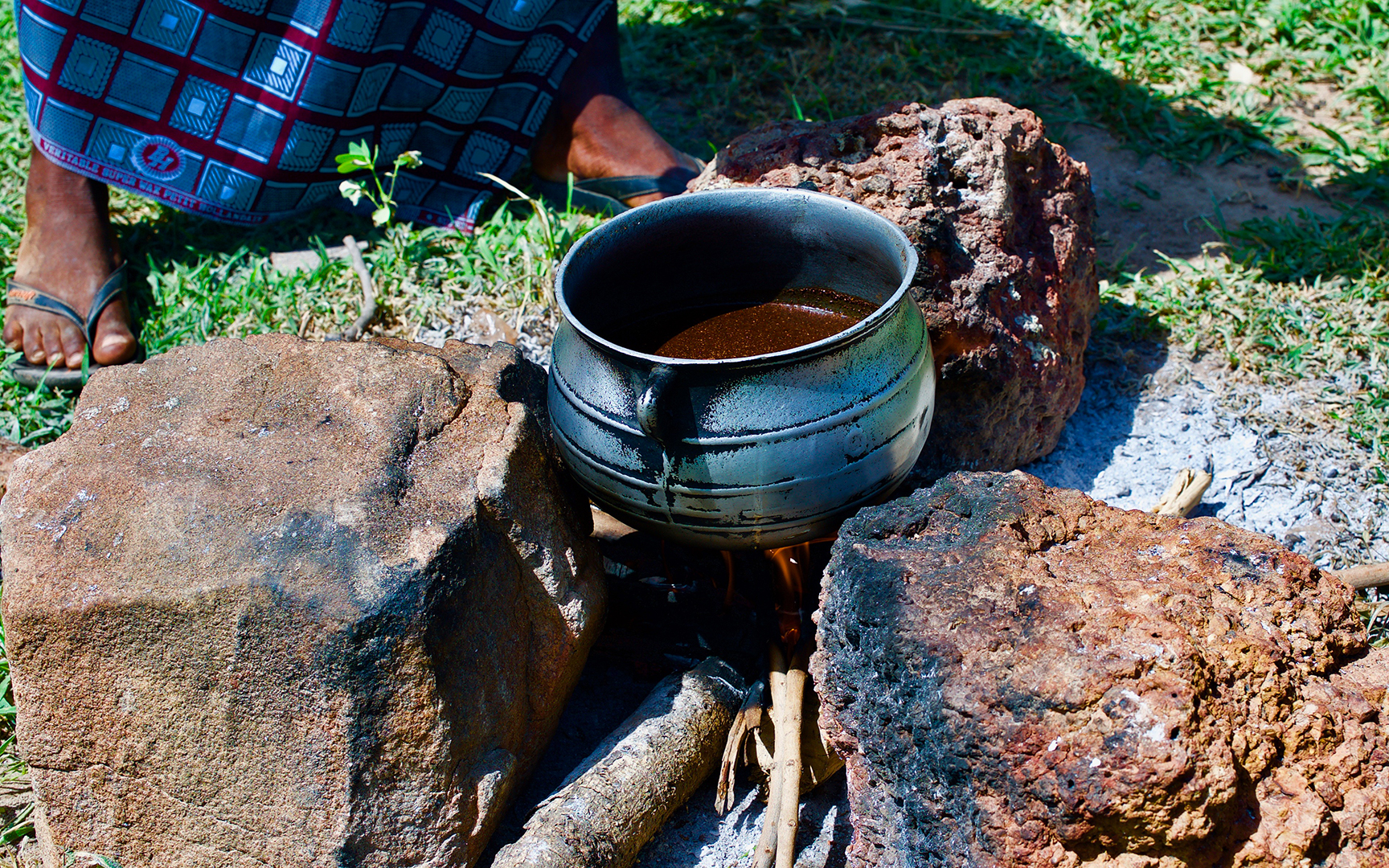 A pot of shea butter boiling over a fire.