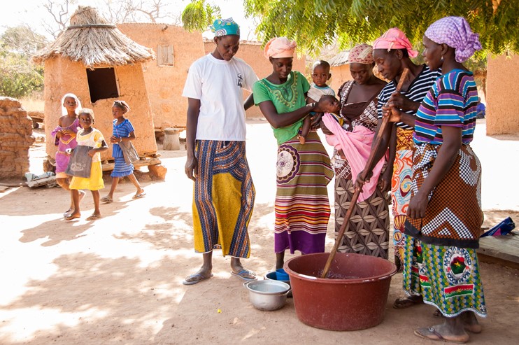 A group of women churning shea butter together