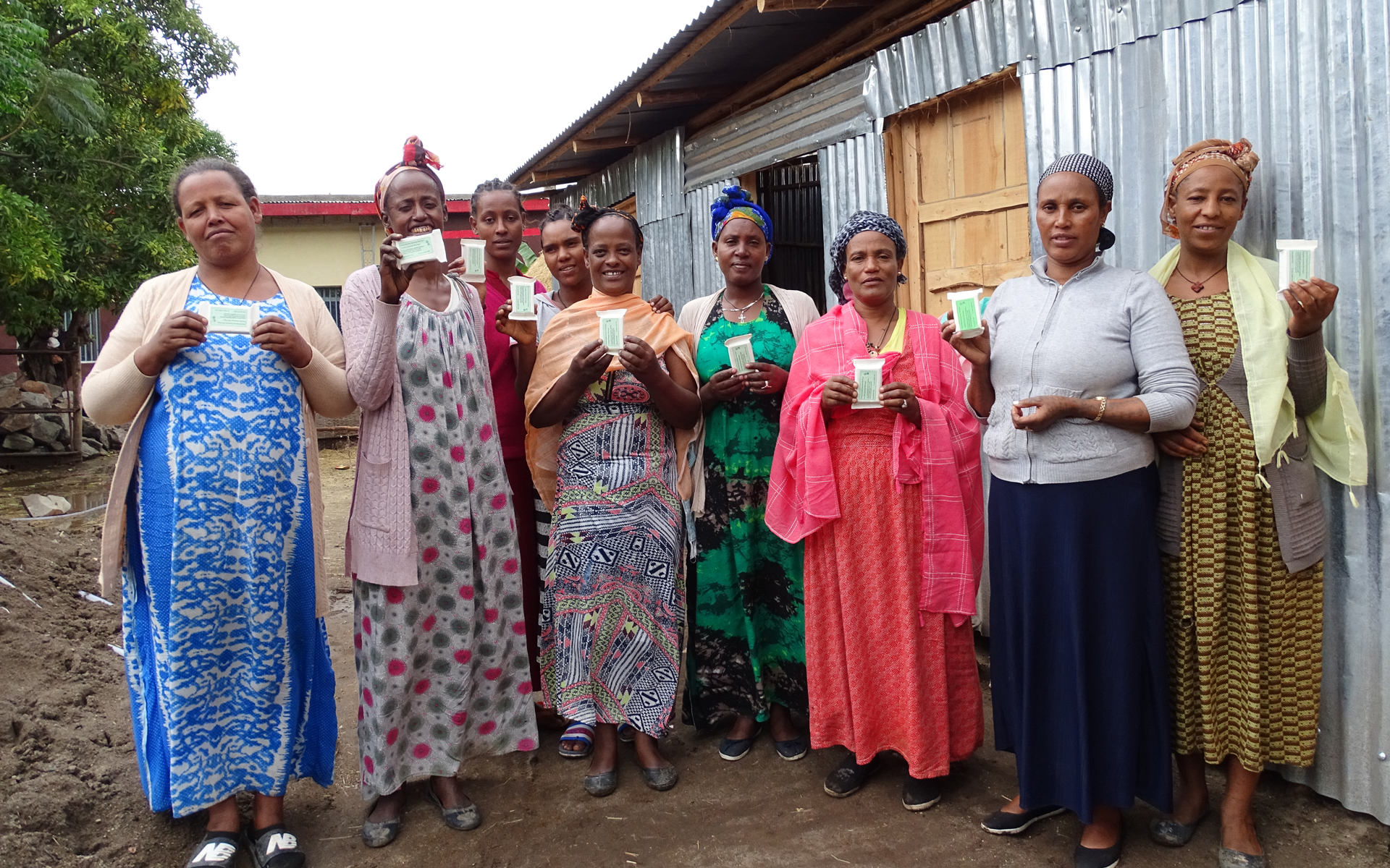 A women's enterprise group holding up their products that they will sell at market.