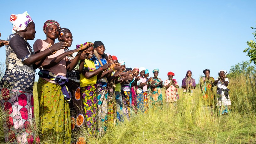 A group of women in Mali standing in a line and clapping.