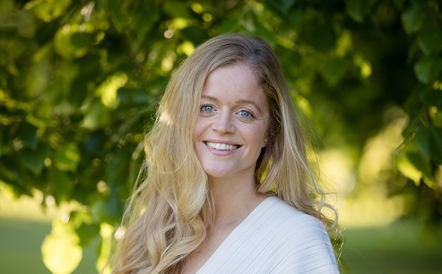 Headshot of Sally Airey, Tree Aid's Communications Manager, stood in front of a tree