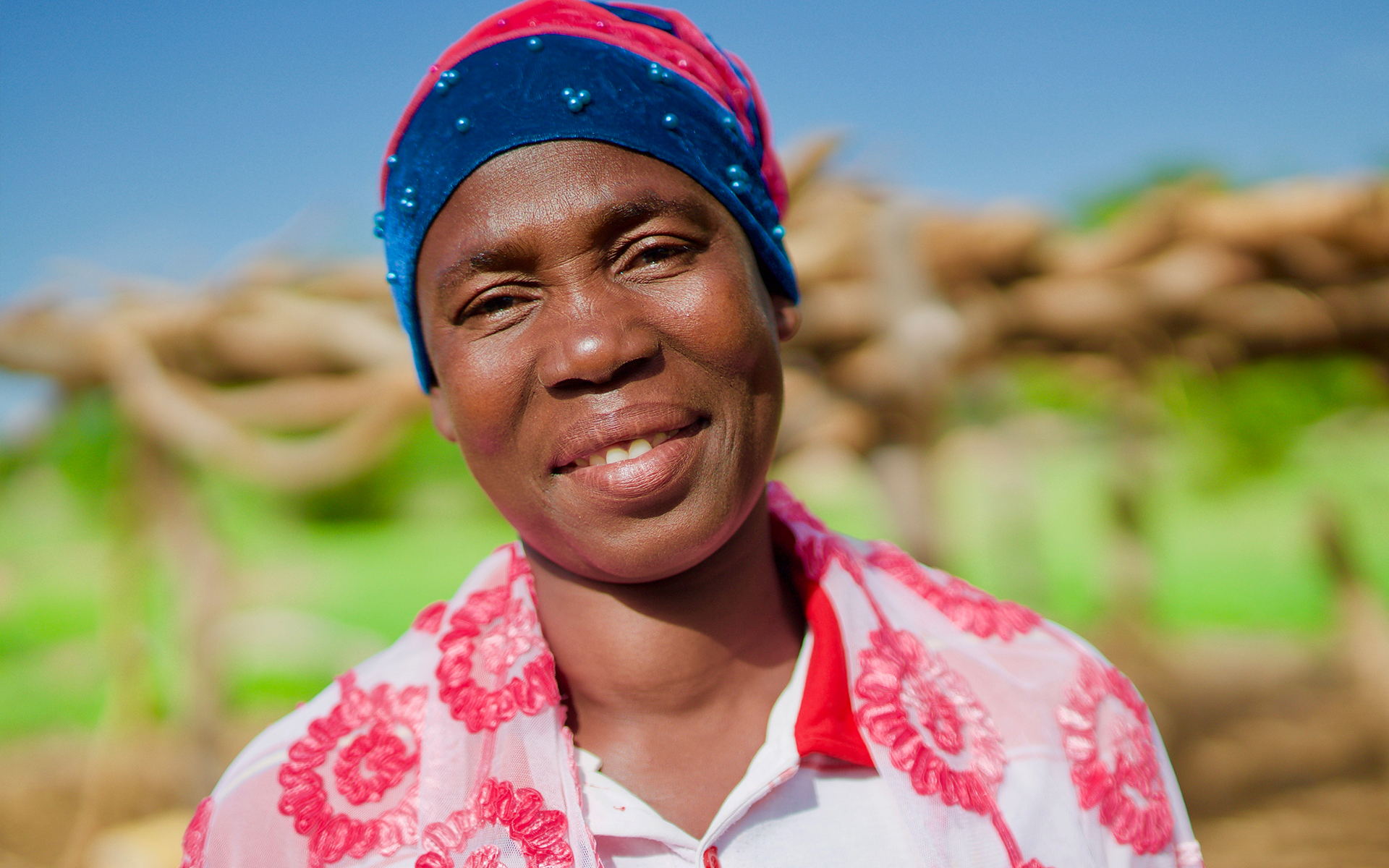 Petra, a member of a shea butter enterprise group in her village, smiling.