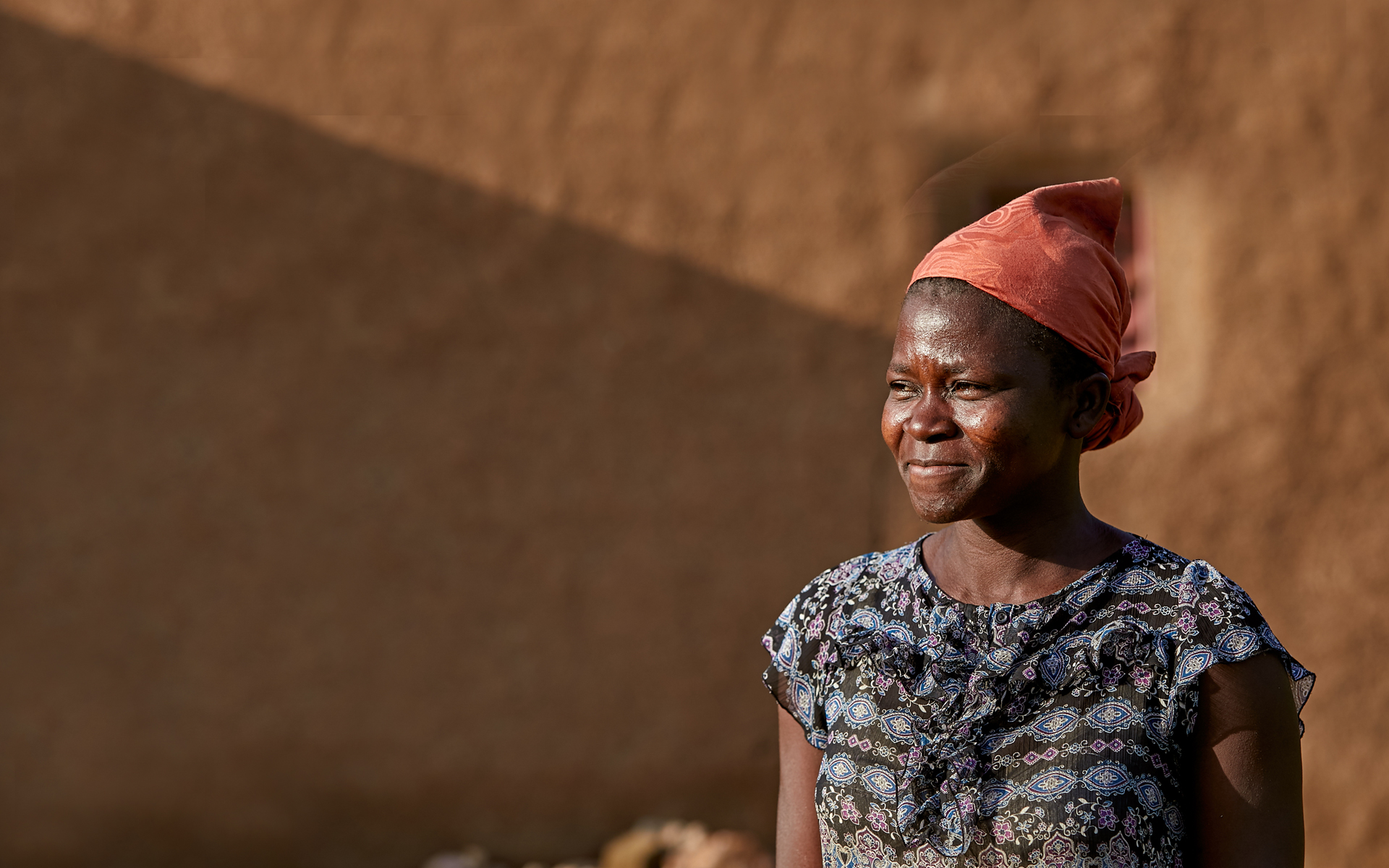 Kachana, a woman we are working with in Ghana, standing outside of her house in Nakolo village