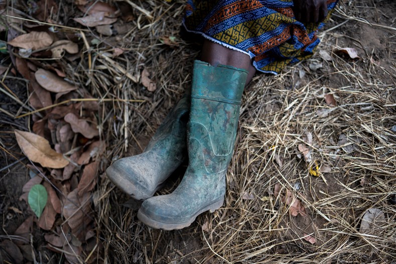 A close up of a woman wearing wellie boots sitting on the ground
