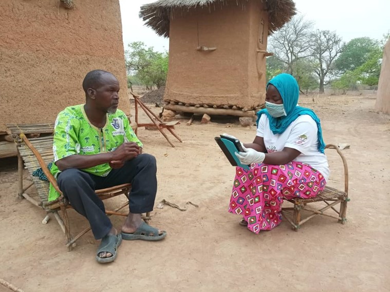A project participant being interviewed for a RHoMIS interview by a Tree Aid partner