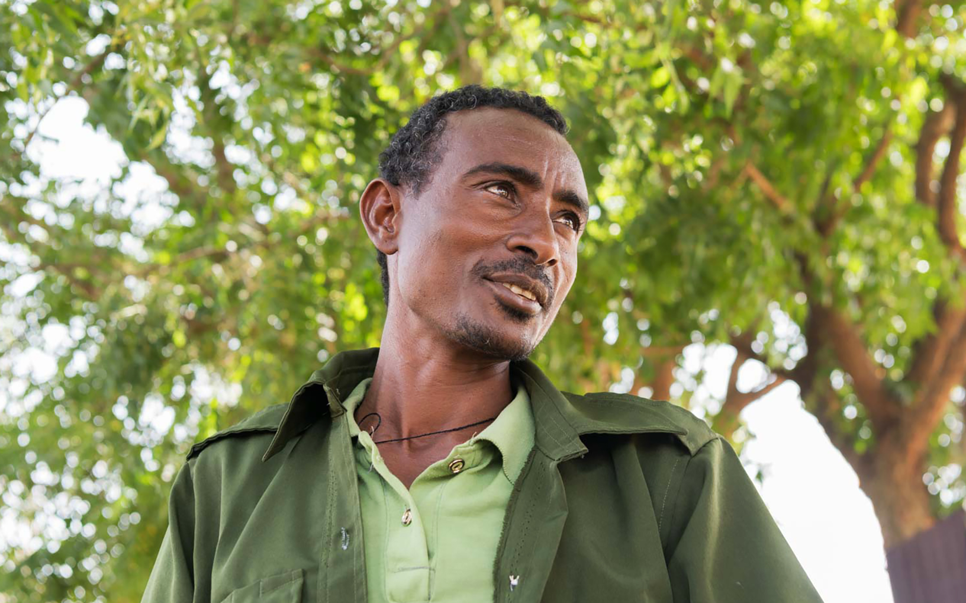 Derese standing in front of a tree
