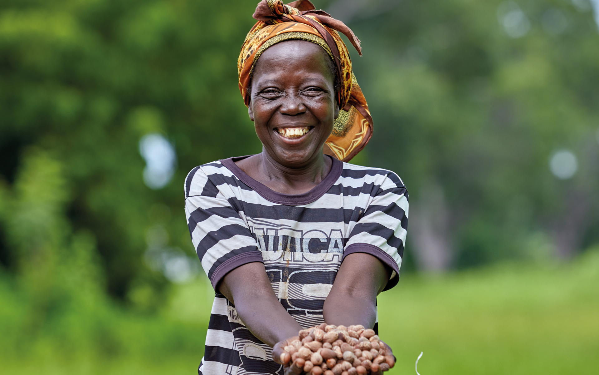 Katumos, a member of Katiu village shea group, holding shea nuts in her village in Ghana
