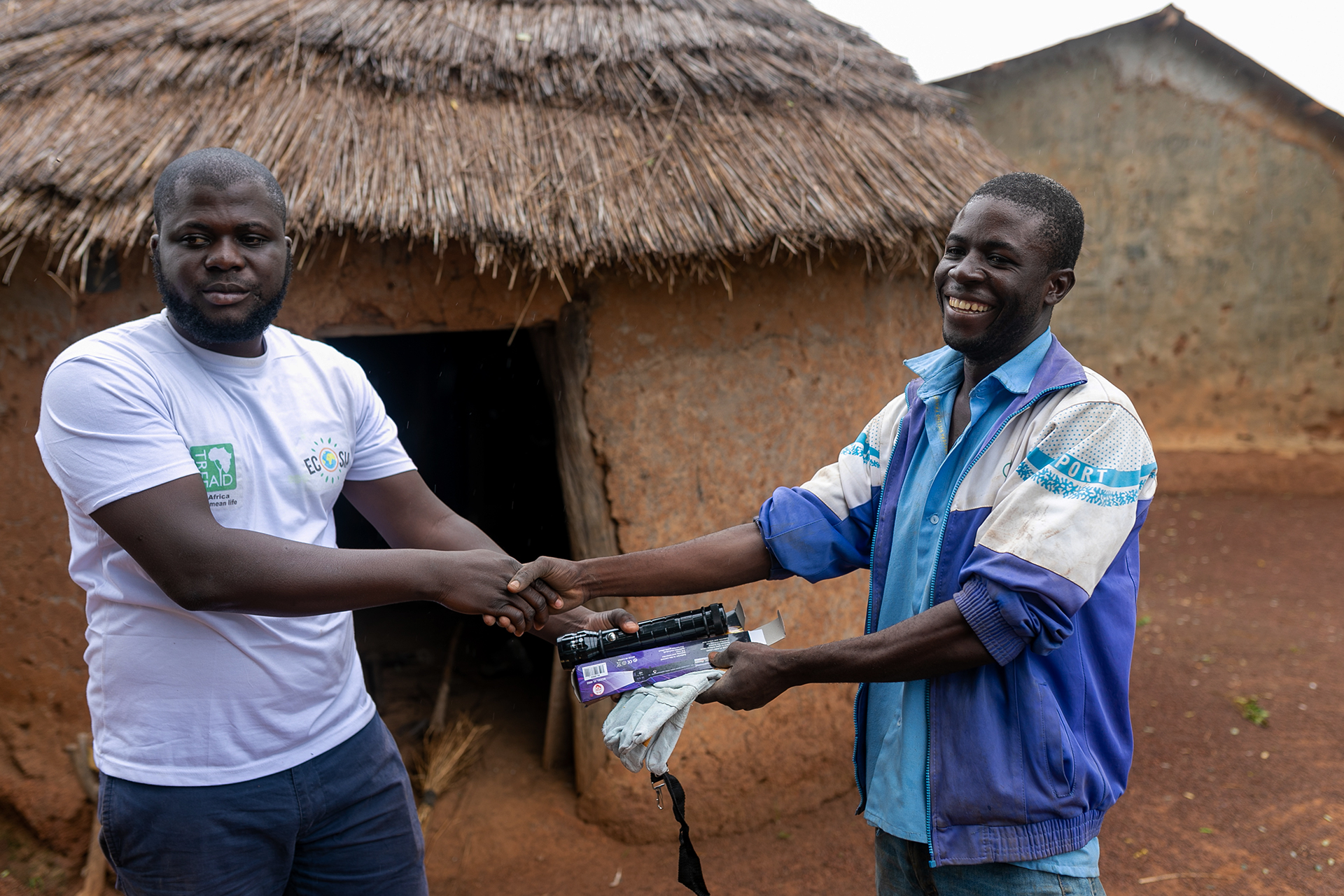 Francis, a man we are working with in Ghana, receiving tools from a Tree Aid staff member.