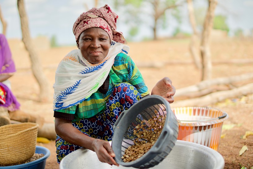 A woman with a bowl of seeds smiling at camera