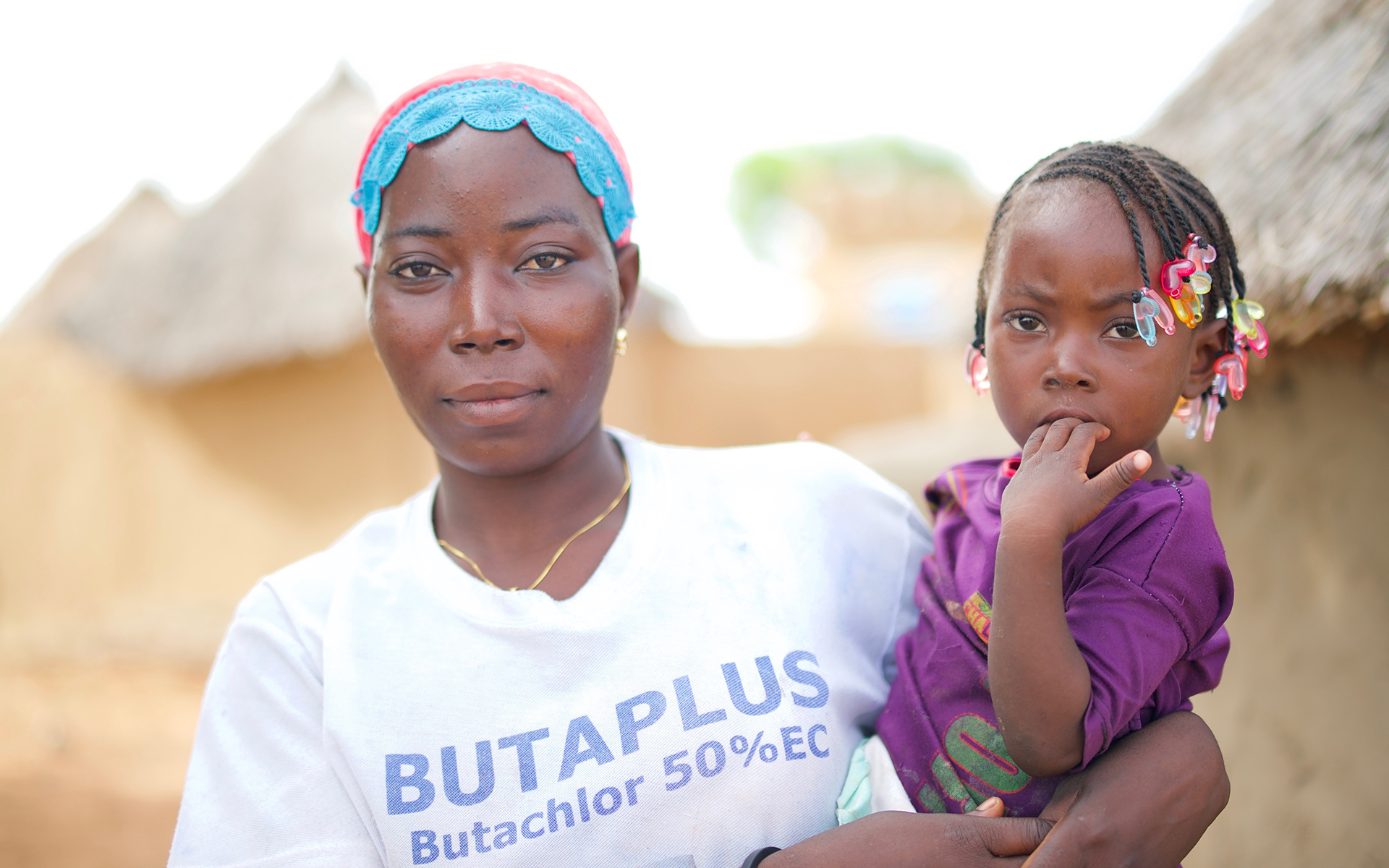 Zalissa, the secretary of her village's soumbala enterprise group, stood outside her home, holding her baby