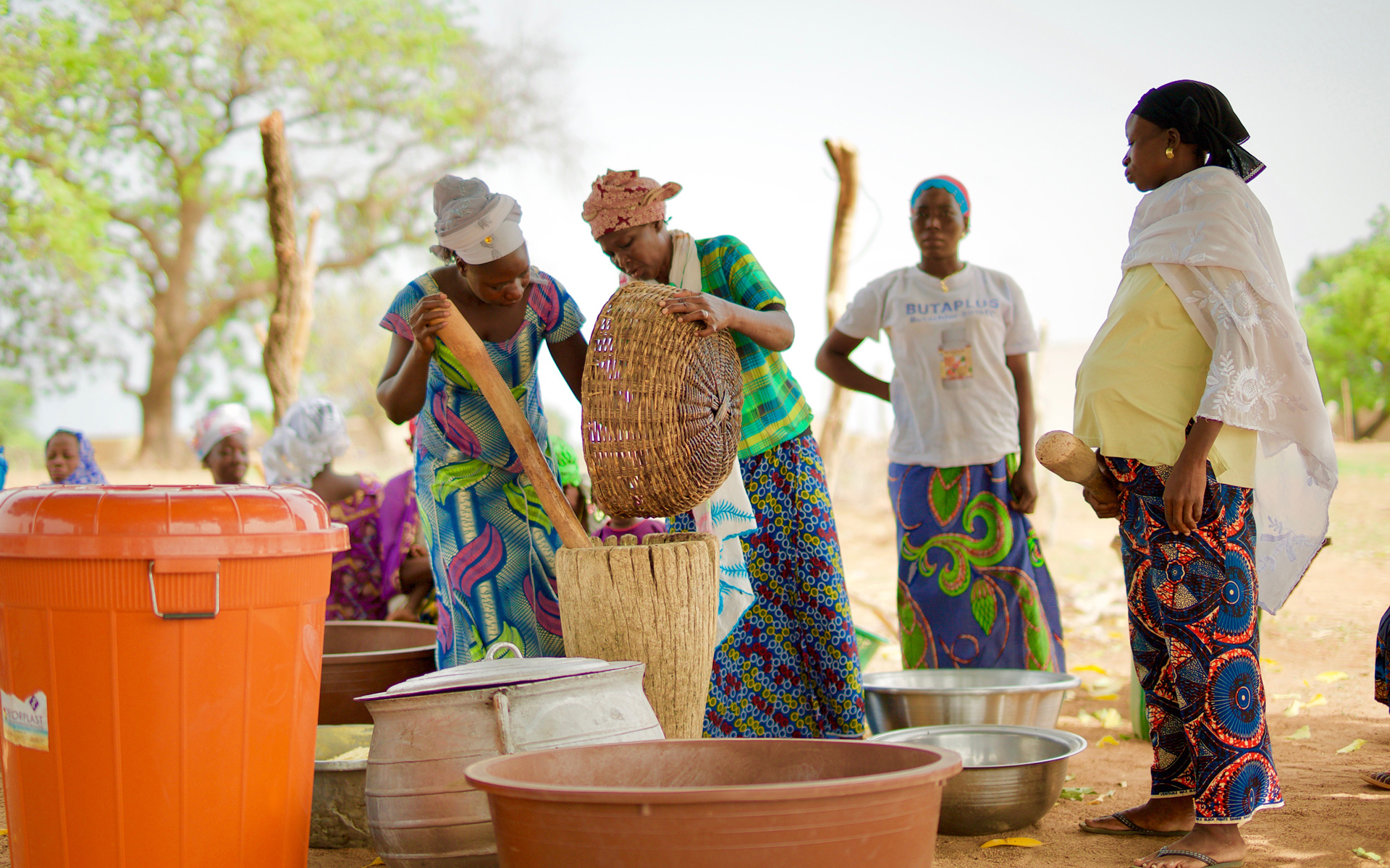Zalissa, the secretary of her village's soumbala enterprise group, processing soumbala with women in her village
