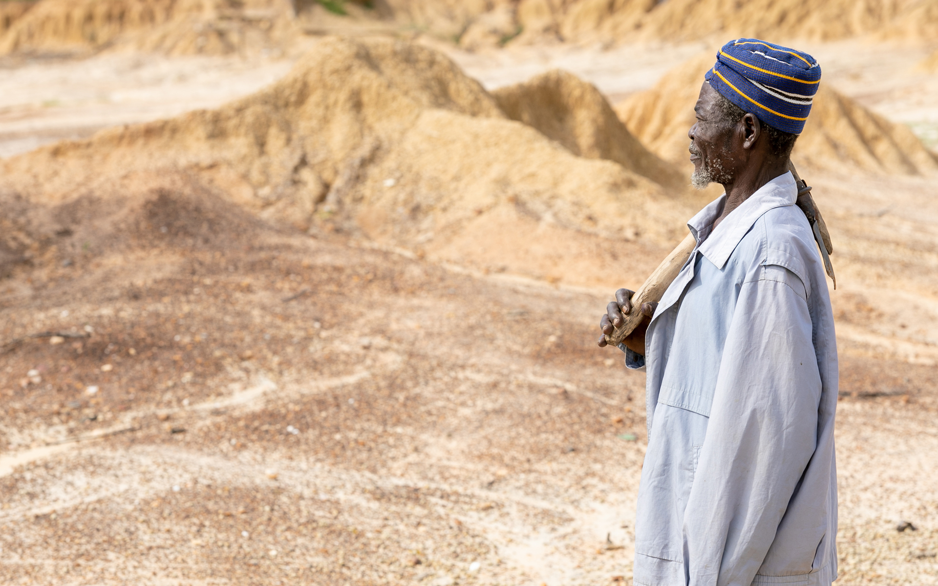 Mbole, a man taking part in a Tree Aid project, is standing looking at his degraded land which he had to leave after the soil was no longer fertile enough for him to grow food for his family.